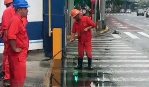 Un ouvrier surpris en train d’essayer de vider une flaque d’eau avec une pelle