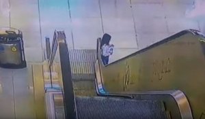 Une fillette emportée par la rampe d'un escalator