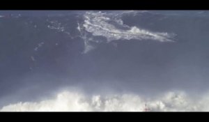 Un homme surfe l'une des plus haute vague du monde au Portugal