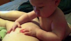 Ce bébé essaye de manger le tatouage d'un piment sur la jambe de sa maman !