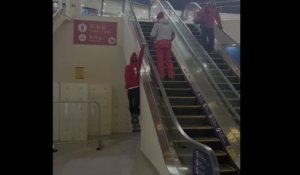 Il monte l'escalator suspendu par la main sur le rebord !