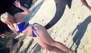 Un éléphant s’amuse à mettre des fessées à une jolie fille sur la plage
