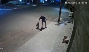 Cet homme couvre un chien qui dort dans la rue