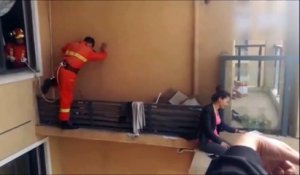 Des pompiers chinois sauvent une femme en haut d'un immeuble