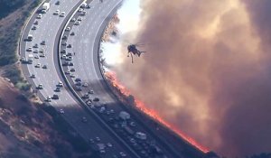 Cet hélicoptère largue des tonnes d'eau sur une autoroute au bord des flammes en Californie