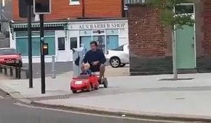 Un enfant conduit sont papa en voiturette électrique