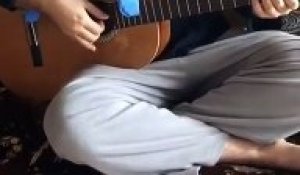 Il joue avec son bébé posé sur la guitare !