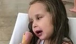 Une petite fille s'endort en mangeant sa glace
