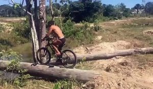 Ce cycliste se rate complètement en traversant une rivière en vélo sur un tronc d'arbre...