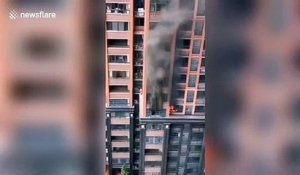 Cet homme s'échappe d'un incendie en escaladant l'immeuble son fils sur le dos