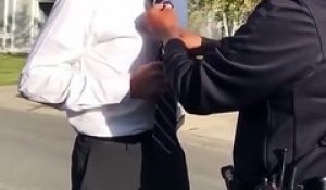 Un policier aide un jeune homme à nouer sa cravate et c'est adorable