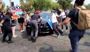 Un manifestant tente de bloquer une voiture de police