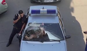 Une femme explose le pare-brise d'une voiture de police