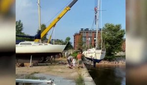 Une grue chute en mettant un bateau à l'eau et tombe sur le bateau en question