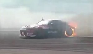 Une voiture de drift termine sa session avec les pneus en feu