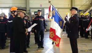 Le Préfet accroche la médaille du mérite et du dévouement sur le drapeau des sapeurs pompiers du Jura.