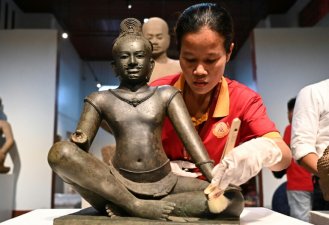 Des moines bouddhistes participent à une cérémonie pour le retour d'oeuvres d'art khmères restituées par le Metropolitan Museum of Art (Met) de New York au musée national de Phnom Penh, le 4 juillet 2024 au Cambodge