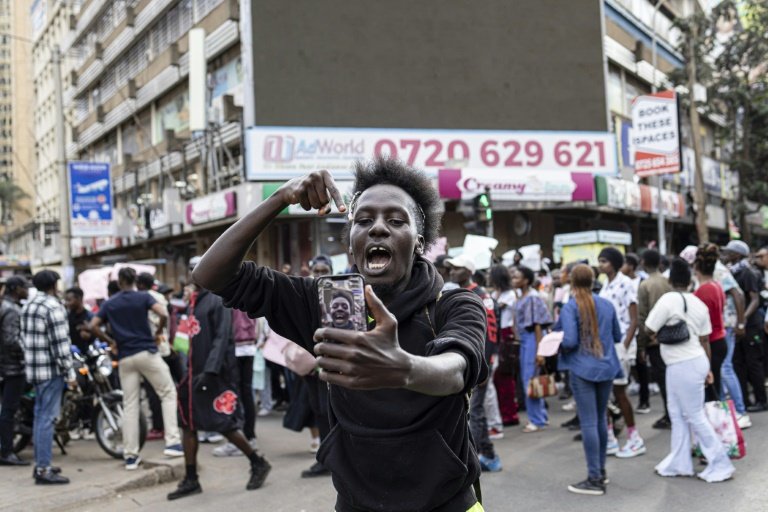 Des jeunes prennent des selfies lors d'une manifestation contre les projets de nouvelles taxes du gouvernement kényan à Nairobi le 23 juin 2024
