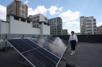 Nazariï Guitchka, directeur de la maternité de Kiev, sur le toit de l'établissement où des ouvriers installent des panneaux solaires, le 14 juin 2024 en Ukraine