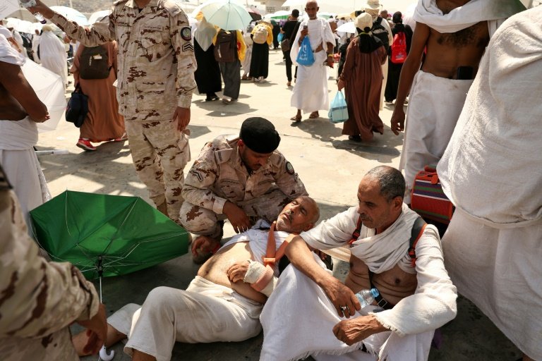Un pèlerin s'asperge la tête d'eau pour se rafraîchir au pied du mont Arafat près de La Mecque en Arabie saoudite, temps fort du hajj marqué par des chaleurs caniculaires, le 15 juin 2024